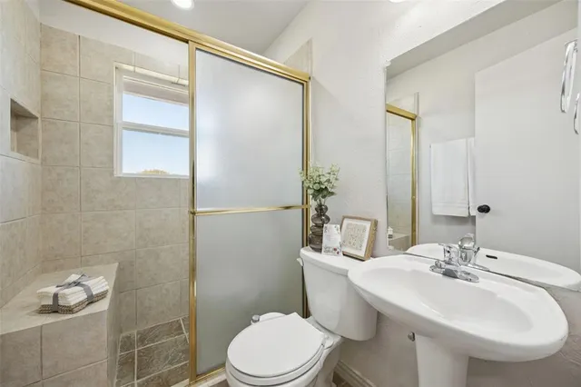 a bathroom with a sink toilet and shower