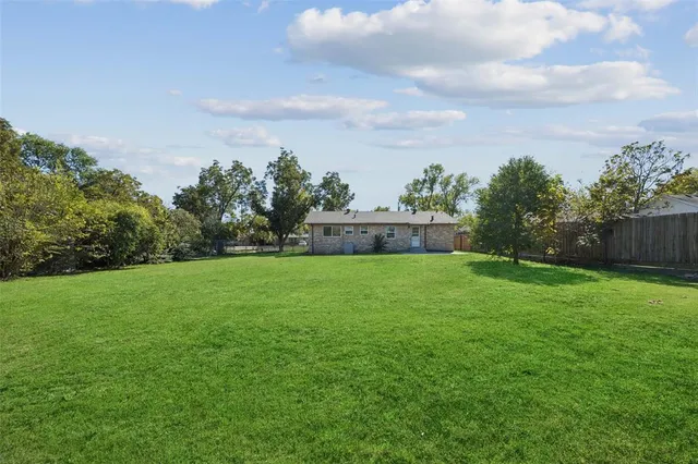 a view of green field with house in the background