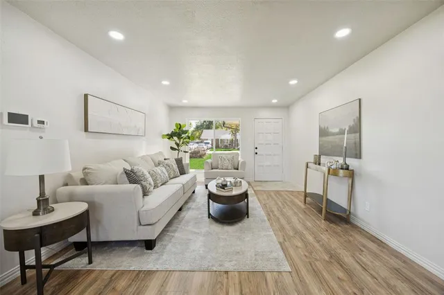 a living room with furniture and a wooden floor