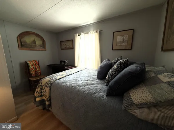a bedroom with a bed and a large mirror next to a window