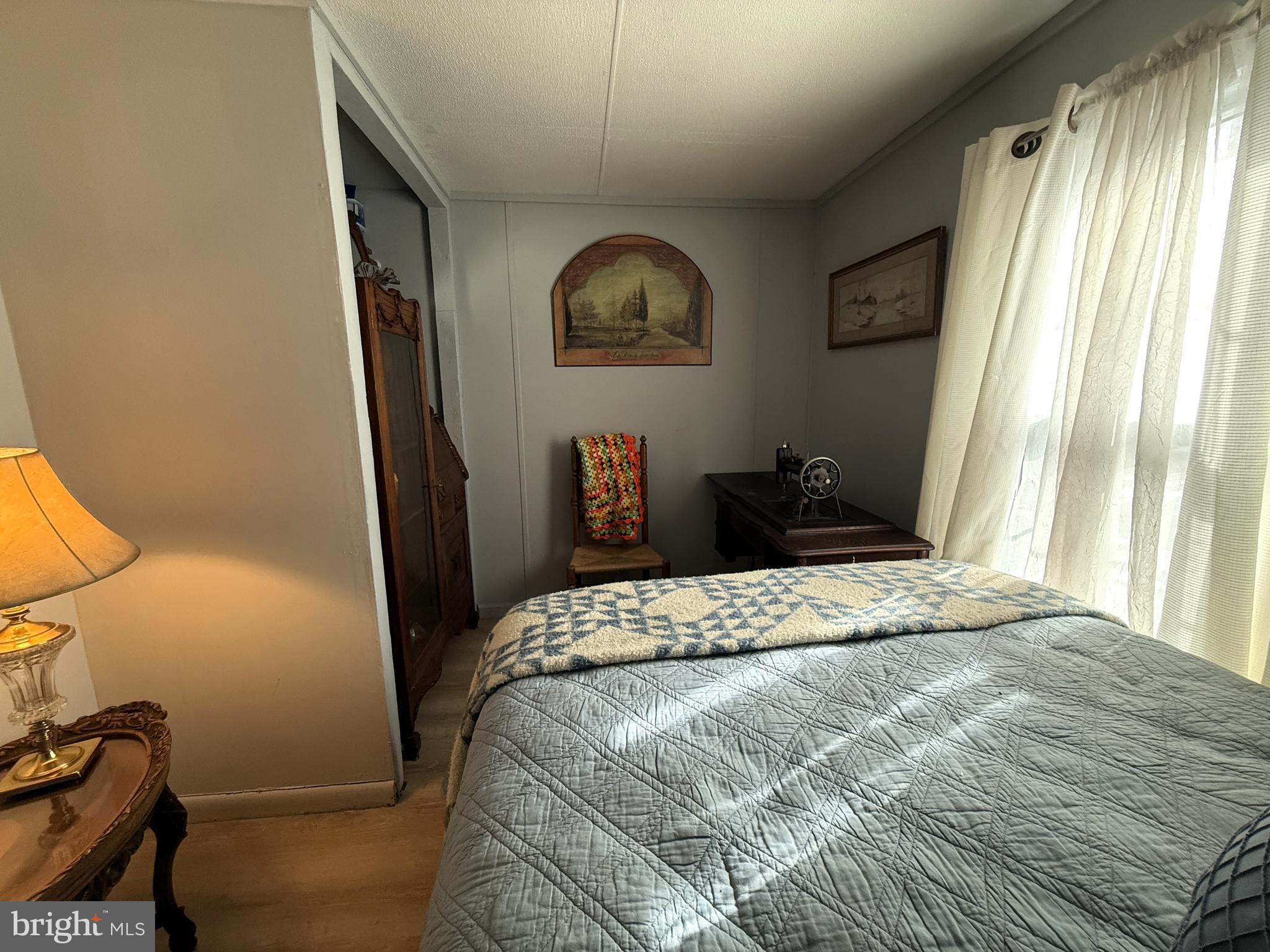 260 Marshall Mill Road, Unit 146 Malaga, NJ 08328 - Photo 18 of 34 a bedroom with a bed and a large mirror next to a window