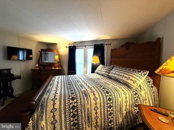a bed sitting in a bedroom next to a window and a mirror