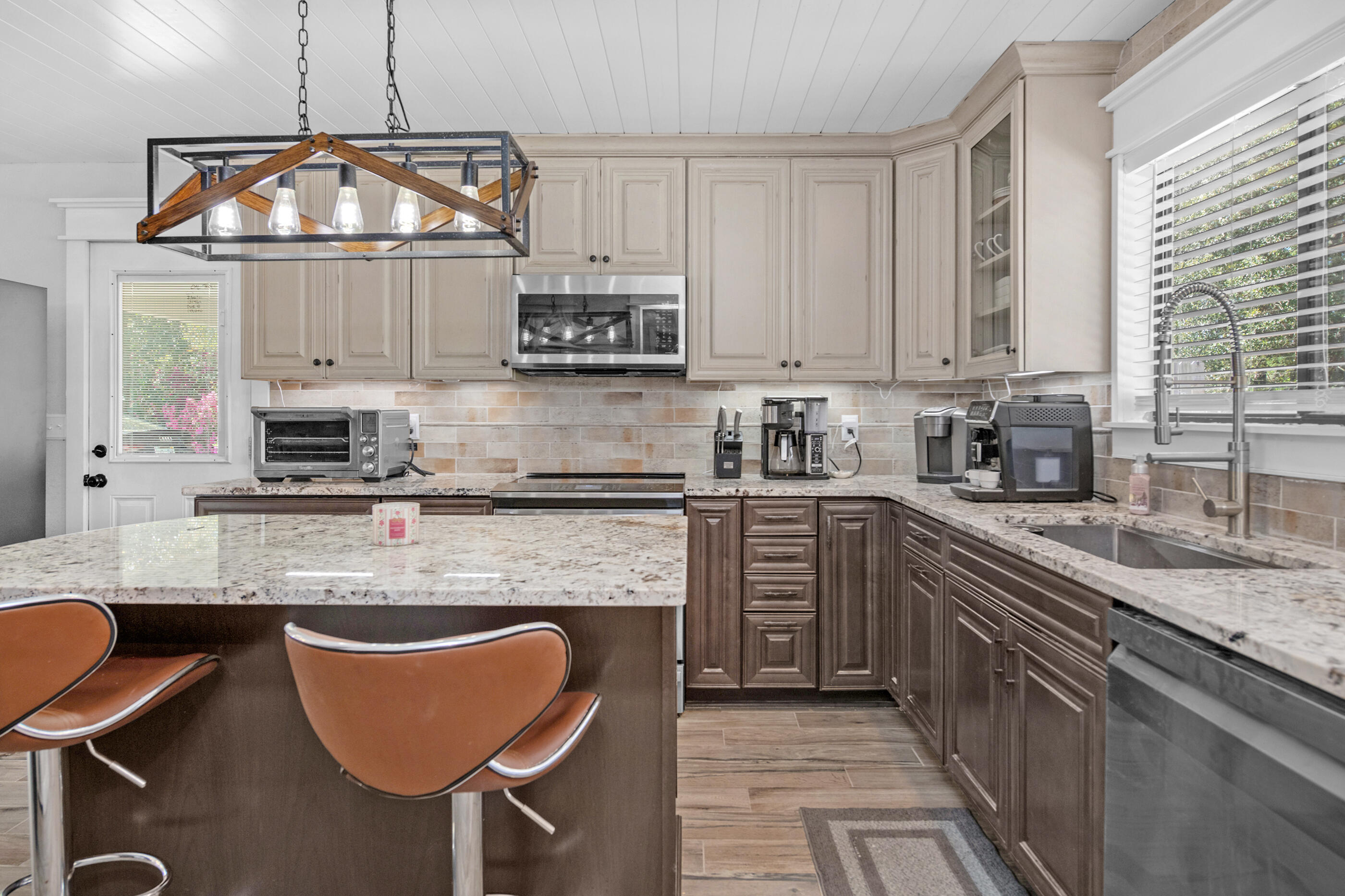 6539 Robar Tesora Street Navarre, FL 32566 - Photo 1 of 48 a kitchen with stainless steel appliances granite countertop a stove top oven a sink dishwasher a dining table and chairs with wooden floor