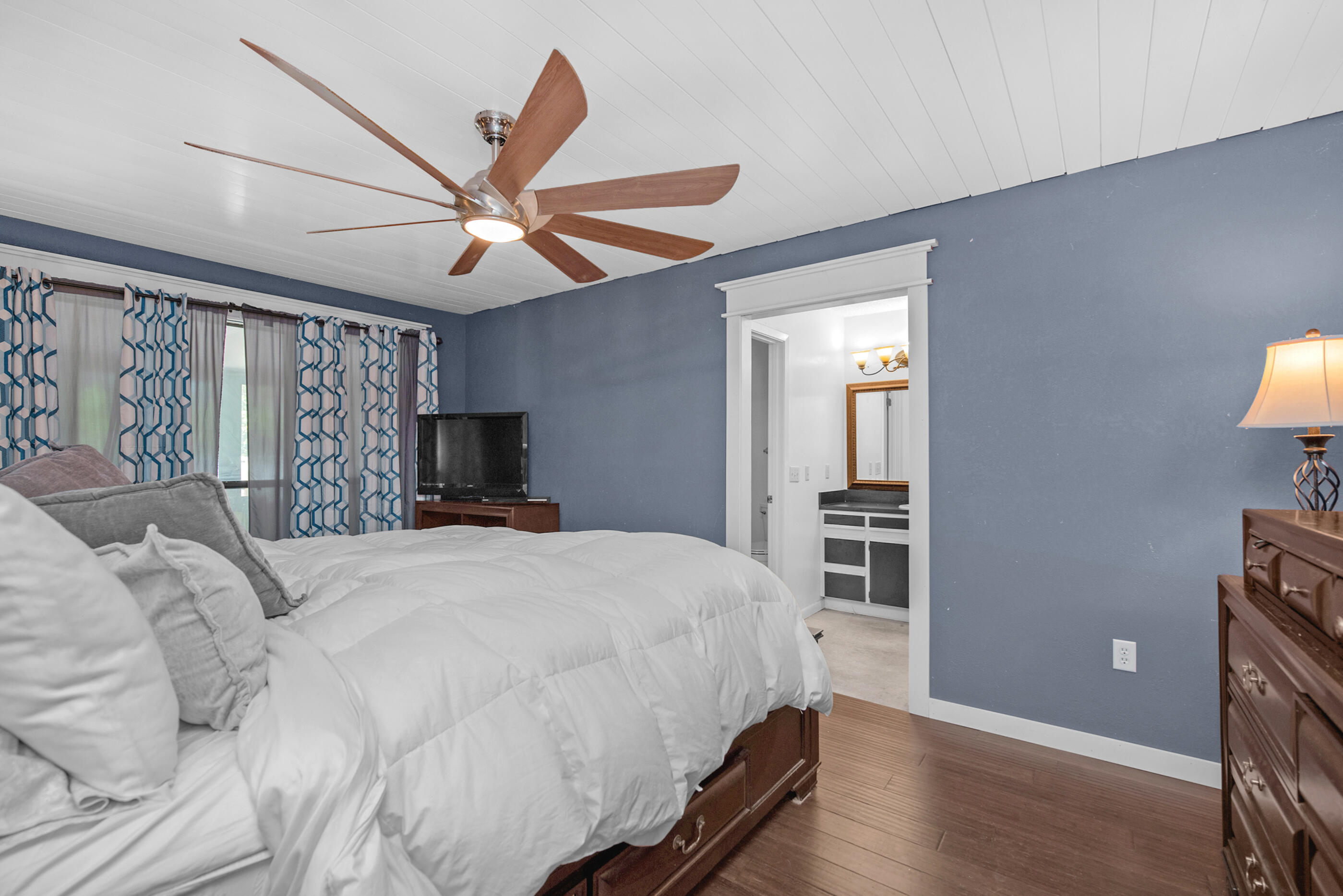 6539 Robar Tesora Street Navarre, FL 32566 - Photo 19 of 48 a bedroom with a large bed and a chandelier