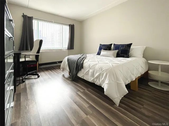 a bedroom with a bed and large windows