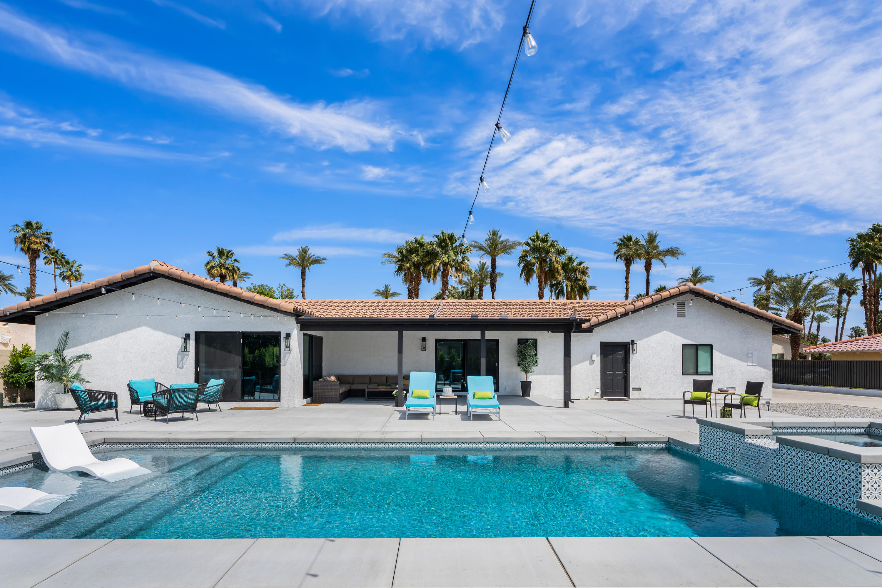 70443 Chappel Road Rancho Mirage, CA 92270 - Photo 6 of 36 a view of a white house with a yard table and chairs