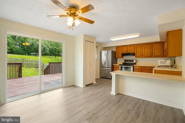 a view of entryway and kitchen with wooden floor