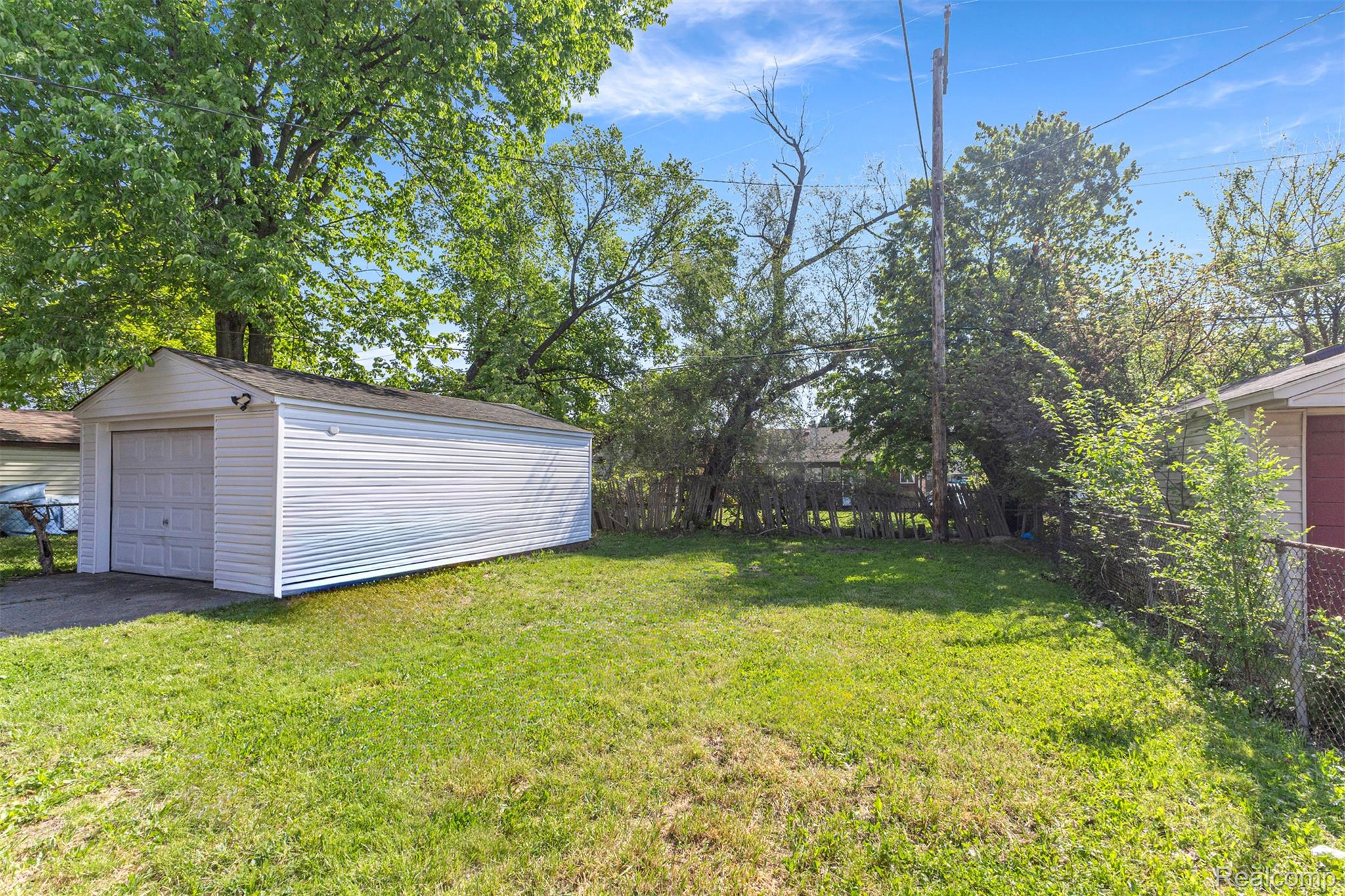 19320 Telegraph Road Detroit, MI 48219 - Photo 24 of 27 Fenced backyard featuring a detached garage, an outdoor structure, and driveway