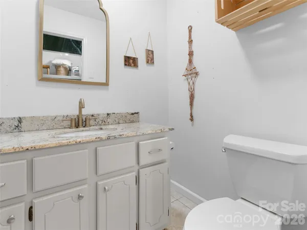 a bathroom with a granite countertop toilet sink and mirror