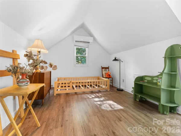 a bedroom with furniture and a wooden floor