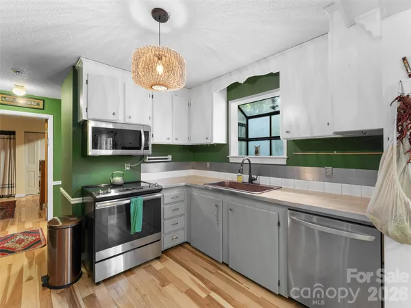 a kitchen with stainless steel appliances granite countertop a sink and a stove