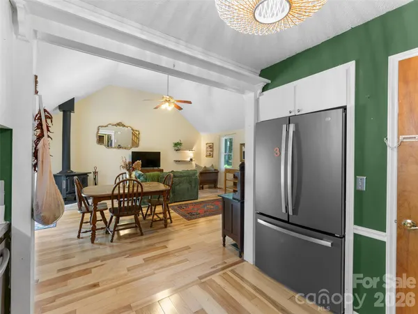 a kitchen with stainless steel appliances a refrigerator a stove top oven and wooden floor