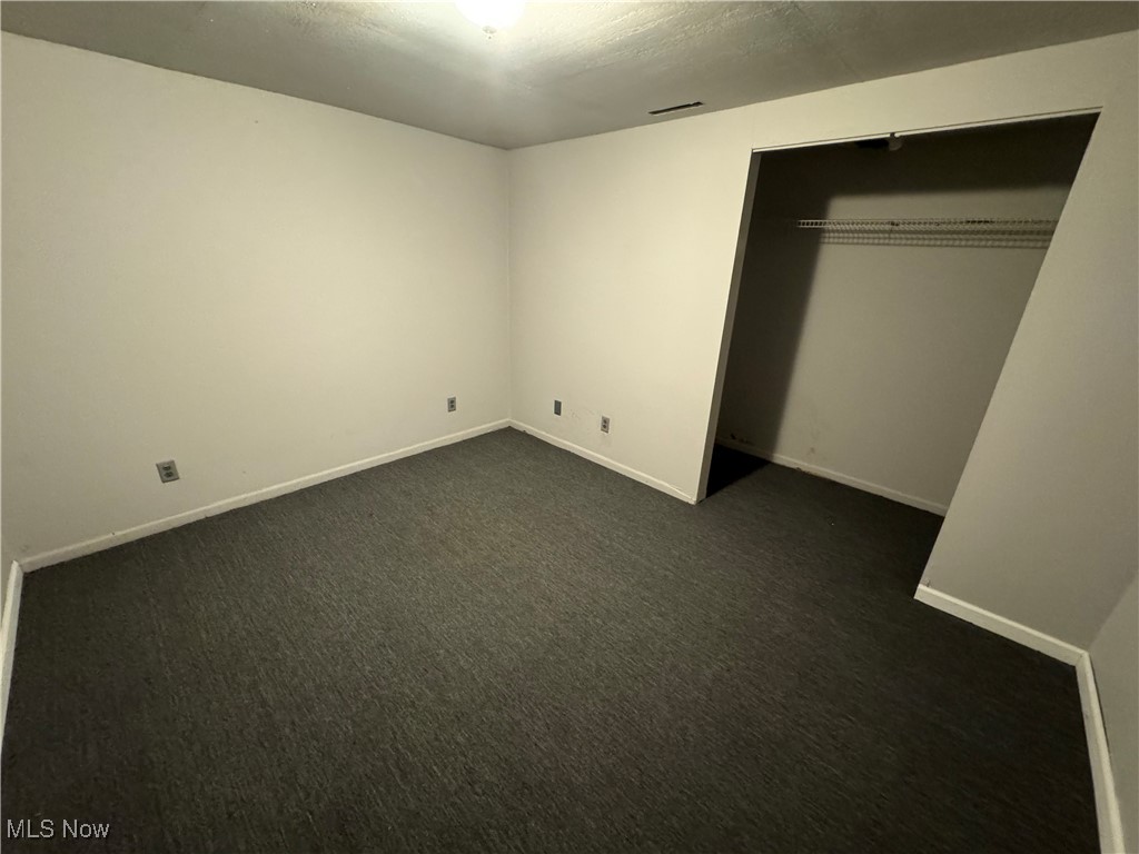 1920 South River Road Zanesville, OH 43701 - Photo 11 of 21 Unfurnished bedroom with dark colored carpet and a closet