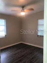 a room with wooden floor and windows