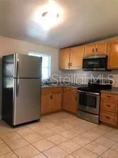 a kitchen with stainless steel appliances granite countertop a refrigerator a stove a sink and a microwave