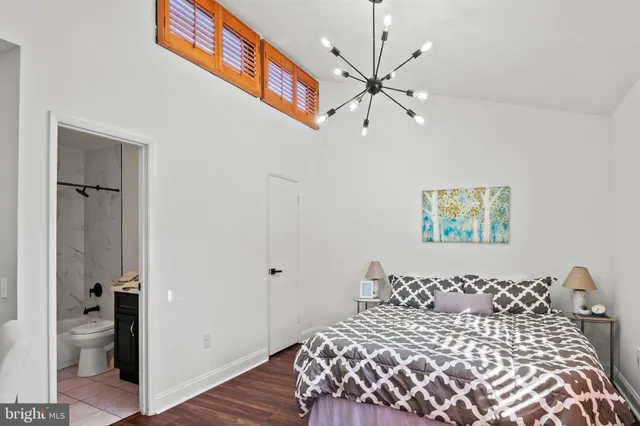 a bedroom with a large bed and a chandelier