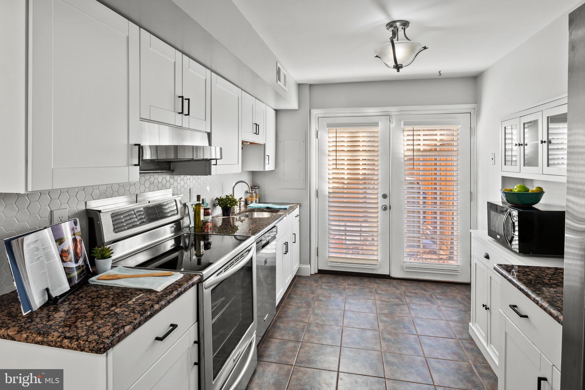 11246 Snowflake Court, Unit A121 Columbia, MD 21044 - Photo 20 of 36 a kitchen with a stove a sink and cabinets