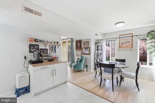 a kitchen with stainless steel appliances a table and chairs in it
