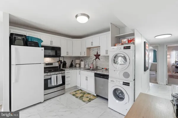 a kitchen with refrigerator a stove top oven and cabinets