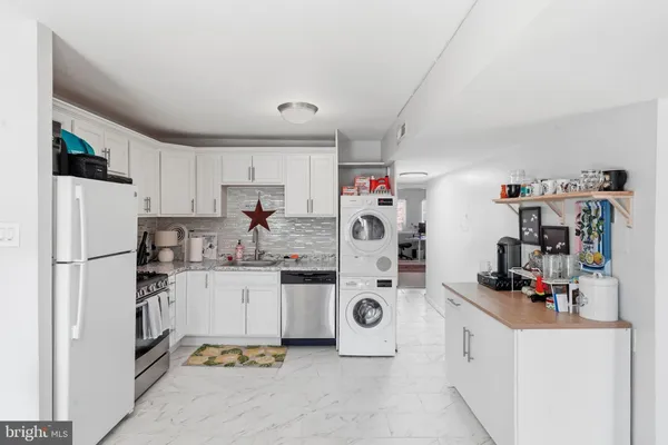 a kitchen with refrigerator and white cabinets