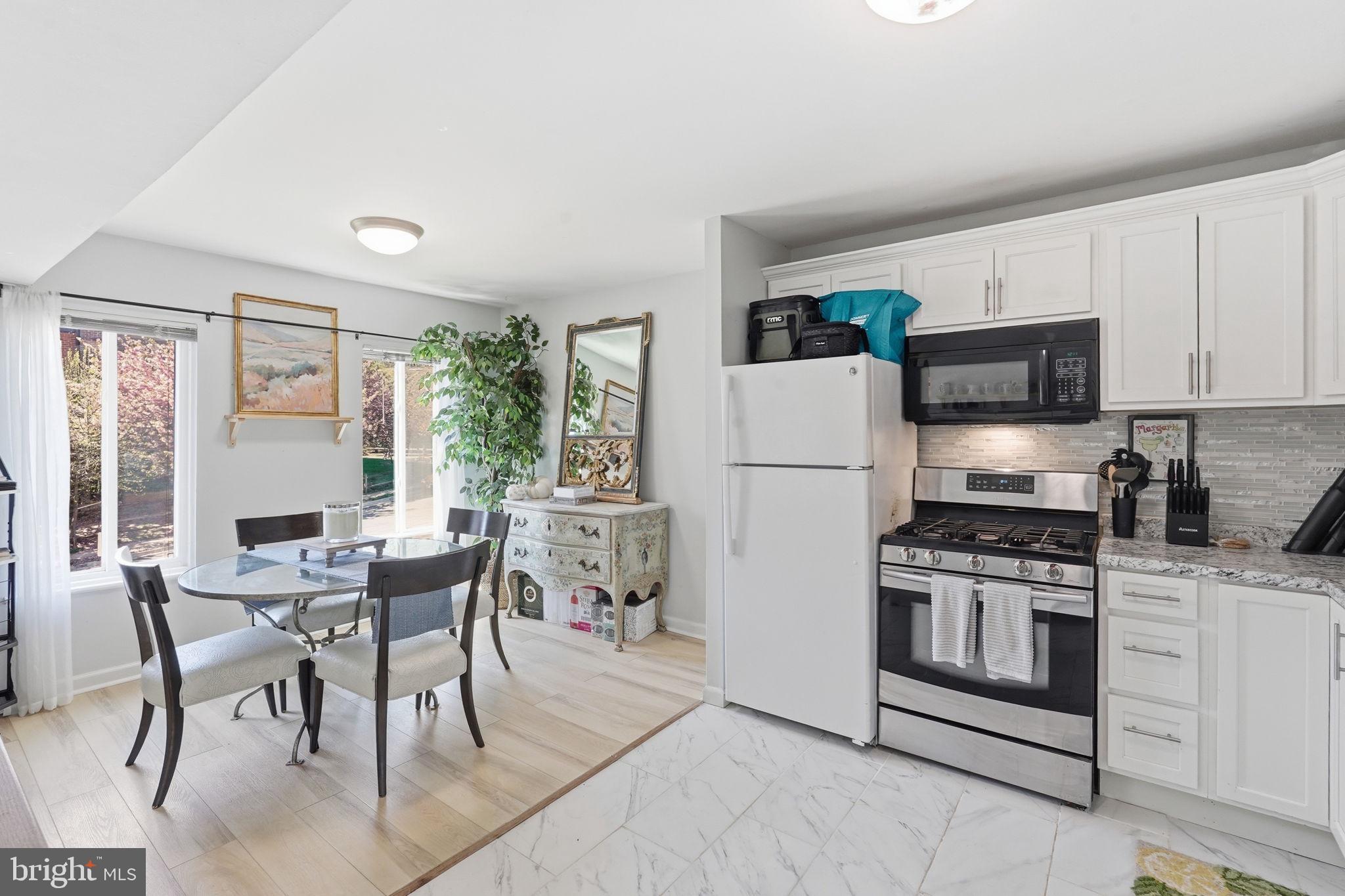 5017 7th Road South, Unit 102 Arlington, VA 22204 - Photo 9 of 40 a kitchen with stainless steel appliances granite countertop a stove a refrigerator a microwave a dining table and chairs