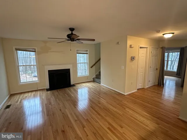 a view of empty room with fireplace and wooden floor