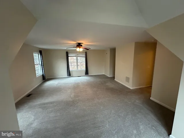 a view of a room with windows and chandelier fan
