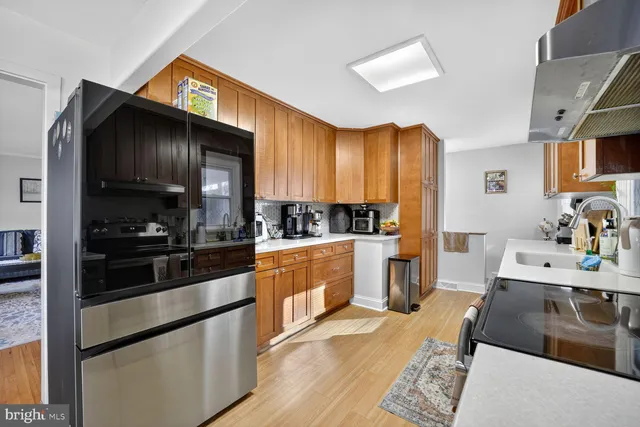 a kitchen with stainless steel appliances wooden floor sink and cabinets