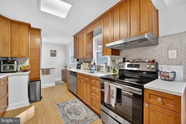 a kitchen with stainless steel appliances sink stove microwave and cabinets