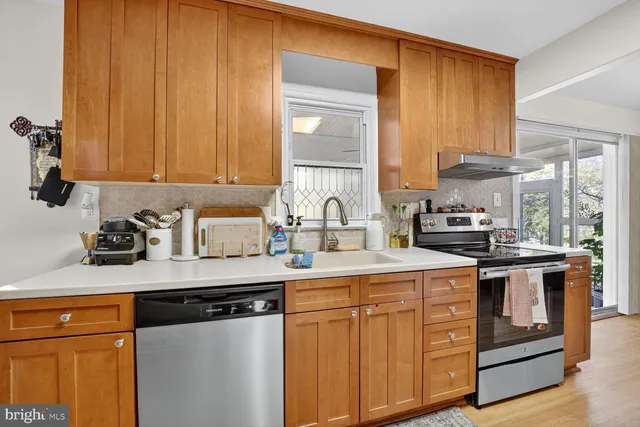 a kitchen with stainless steel appliances granite countertop a sink stove and cabinets