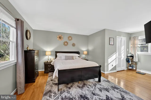 a bedroom with a bed and a large window