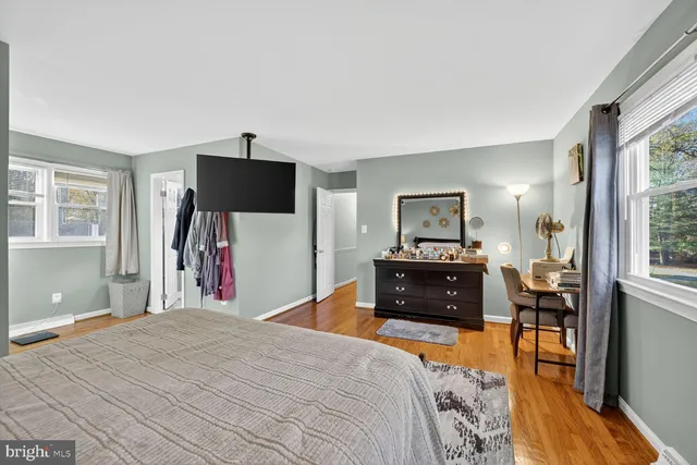 a bedroom with a bed and a flat tv screen on dresser