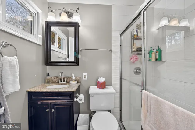 a bathroom with a sink vanity mirror and toilet