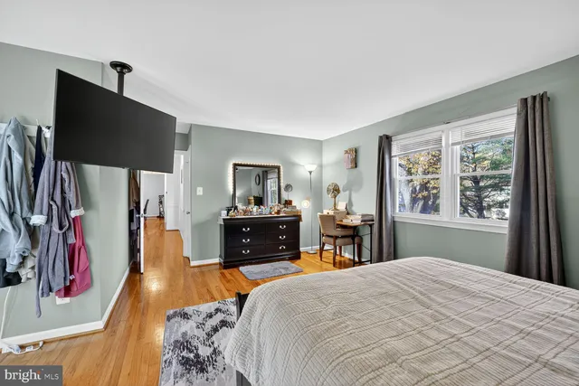 a bedroom with a bed dresser and flat tv screen