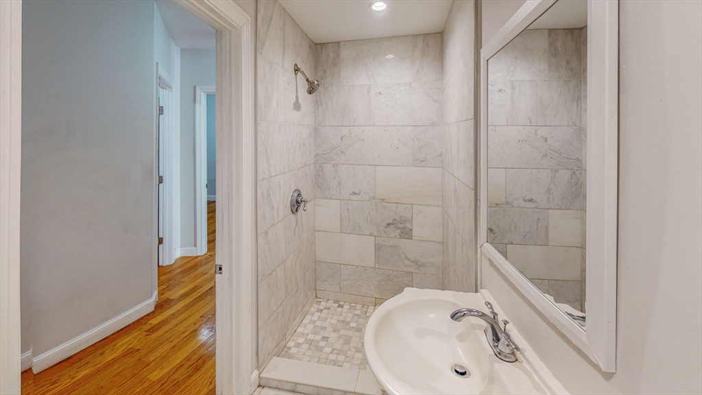 67 Marion Street, Unit 2 Boston, MA 02128 - Photo 8 of 15 a bathroom with a sink a toilet and shower