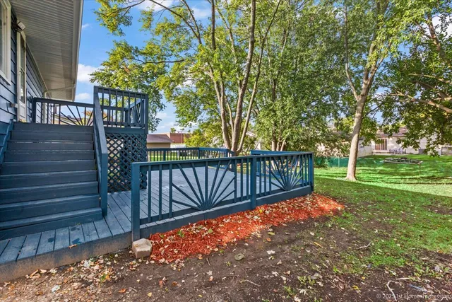 a view of a yard with wooden fence and large trees