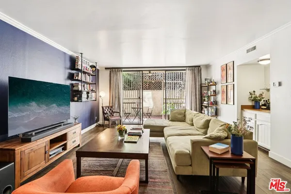 a living room with furniture a flat screen tv and floor to ceiling window
