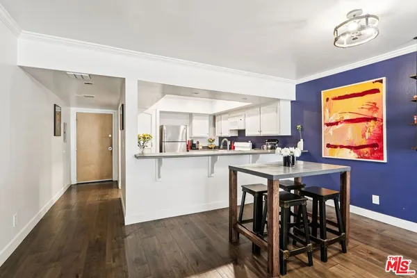 a kitchen with stainless steel appliances granite countertop a dining table chairs and chandelier