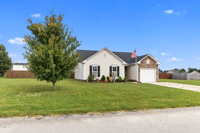 a front view of a house with a yard and garage