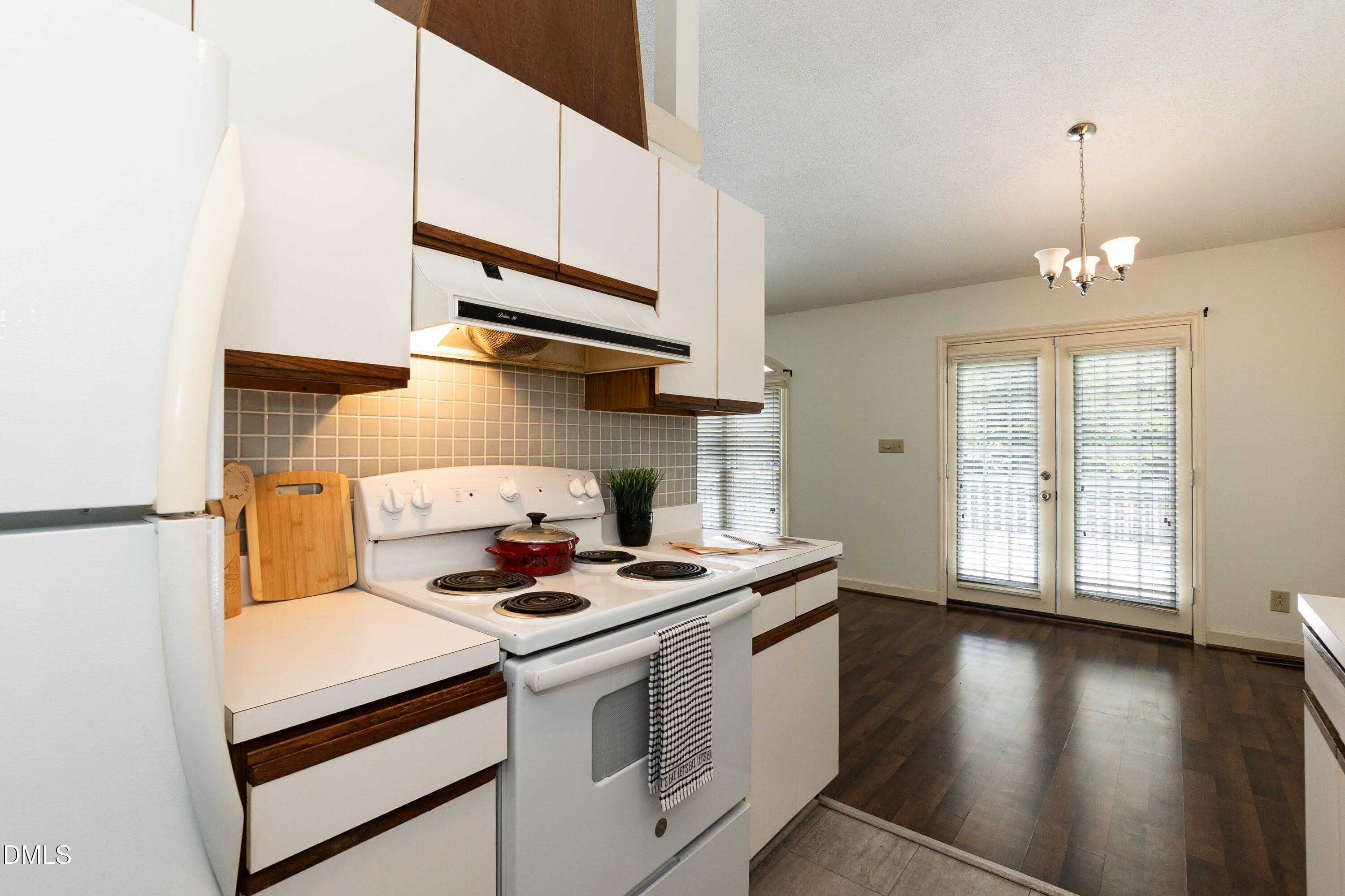 5604 Spring Pines Way Raleigh, NC 27616 - Photo 9 of 22 a kitchen with stainless steel appliances a white stove top oven and a refrigerator with wooden floor
