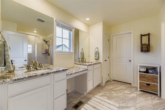 a spacious bathroom with a granite countertop sink and a mirror