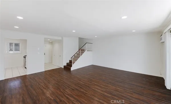 a view of empty room with wooden floor and stairs