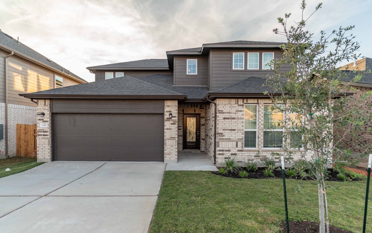 a front view of a house with a garden and garage