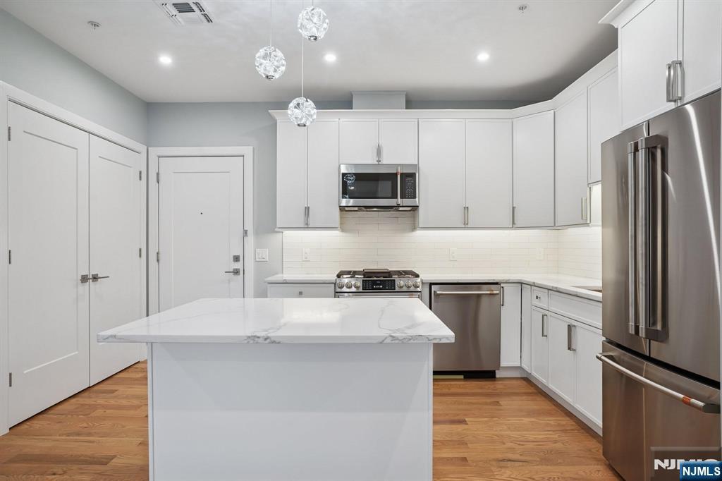 108 Montgomery Street Bloomfield, NJ 07003 - Photo 3 of 31 a kitchen with kitchen island a sink stainless steel appliances and cabinets