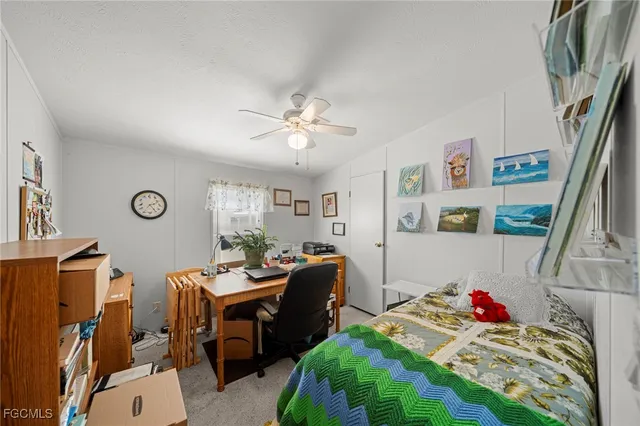 a bedroom with a bed a clock on the wall and dresser