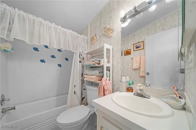 a bathroom with a sink vanity mirror and toilet