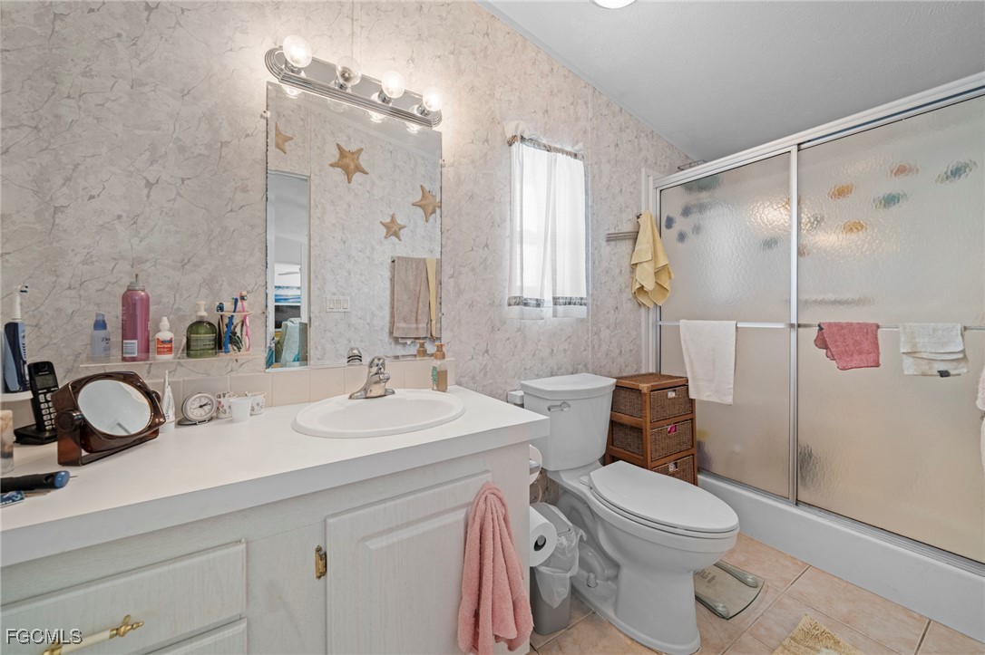 370 Nicklaus Boulevard North Fort Myers, FL 33903 - Photo 18 of 30 a bathroom with a sink vanity mirror and toilet