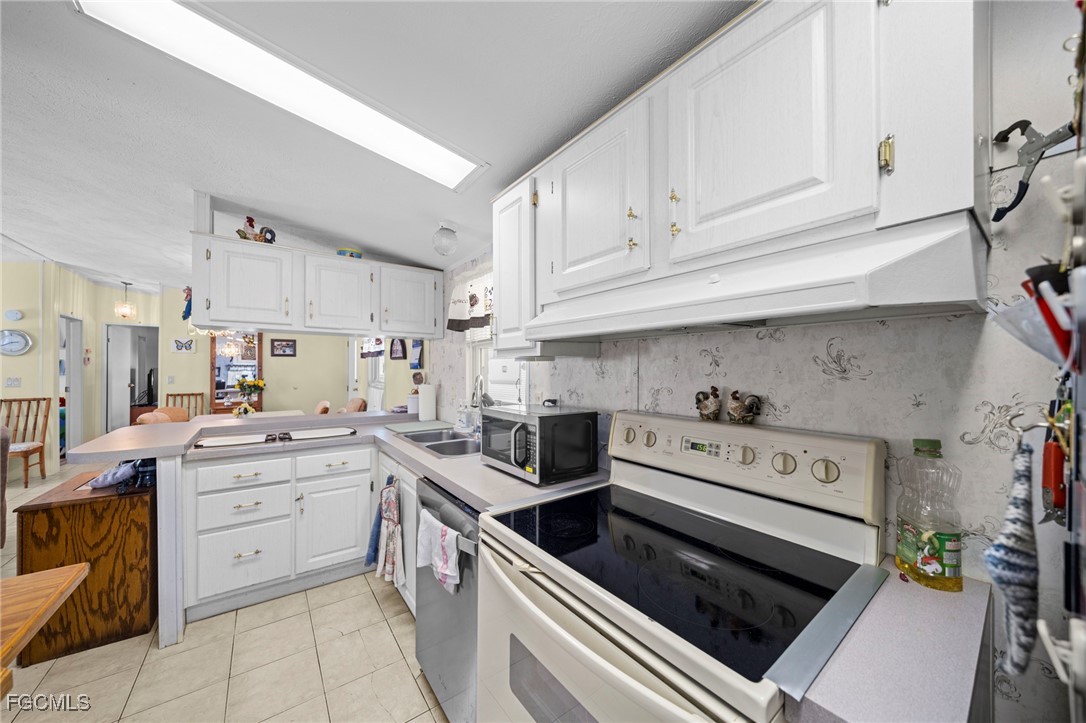 370 Nicklaus Boulevard North Fort Myers, FL 33903 - Photo 8 of 30 a kitchen with stainless steel appliances granite countertop cabinets and stove top oven