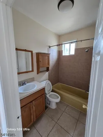a bathroom with a granite countertop sink a toilet a mirror and shower