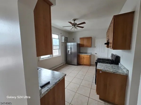 a kitchen with granite countertop a sink a counter top space cabinets stainless steel appliances and a window